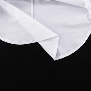 Vue détaillée de l'ourlet arrondi d'une chemise blanche en coton avec coutures soignées