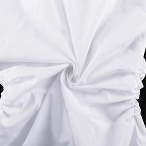 Gros plan sur le tissu en coton blanc montrant les détails froncés et la texture tissée