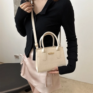 Chic cream crocodile pattern tote bag with gold metal trim and crossbody strap