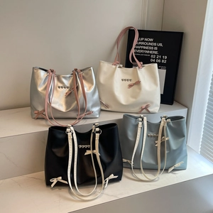 Stylish bow shoulder bag with heart metallic accents in silver, cream, black, and blue