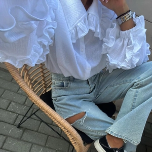 Détail du chemisier blanc en coton avec col à volants et manches lanterne victoriennes