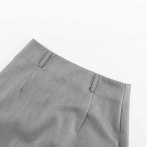 Close-up of high-waist grey skirt belt loops and vertical texture fabric detail