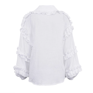 Détail du dos d'une blouse en coton blanc avec volants et texture gaufrée en mousseline
