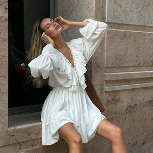 Detail of elegant V-neck ruffled dress with layered textures and long lantern sleeves