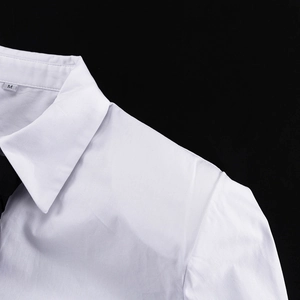Dettaglio ravvicinato del colletto della camicia di cotone bianco e etichetta taglia M interna