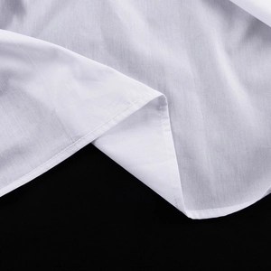 Dettaglio macro dell'orlo arrotolato a doppia cucitura su una camicia bianca di cotone