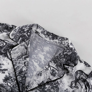 Detalle de cuello de solapa con ribete negro en camisa con estampado Toile de Jouy blanco y negro