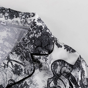 Vista detallada del cuello con estampado de estilo tinta, ribete negro y etiqueta talla M
