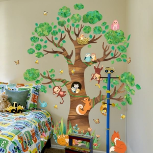 Detail of cartoon forest tree wall decal showing animal characters on a corner wall