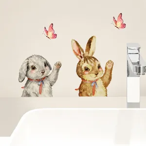 Detailweergave van muurstickers met paashaas en vlinders op een beige badkamerwand