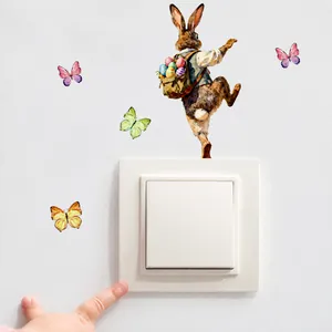 Detail van de paashaas muursticker met kleurrijke vlinders rond een lichtschakelaar