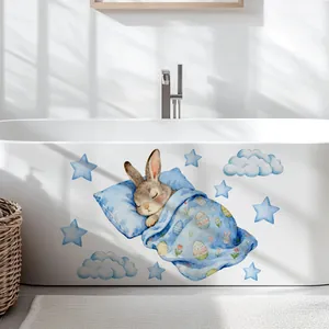 Detailed view of luminous blue rabbit wall stickers applied to a white bathtub side