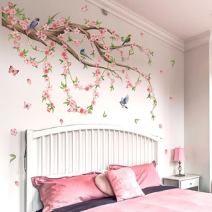 Detail of pink cherry blossom wall stickers with birds on branches in a bedroom setting