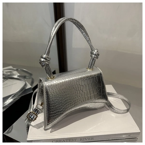 Detail of silver crocodile pattern mini bag with curved base and knot handle
