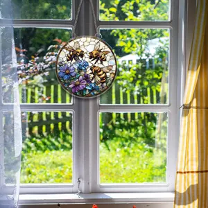 Detailansicht eines 2D-Acryl-Sonnenfängers mit Bienen und Blumen am Fenster hängend