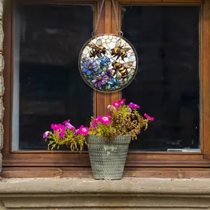 Detail eines runden Bienen-Blumen-Hängeschilds an einem rustikalen Holzfenster