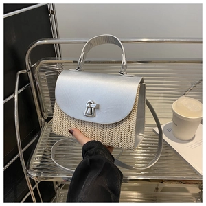 Detail der handgewebten Strohtasche mit silberner Klappe und sicherem Drehverschluss