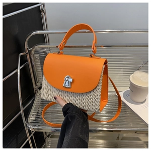 Detail der orangefarbenen Lederklappe und des Flechtkörpers einer Damen-Handtasche