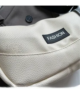 Macro shot of off-white lychee pattern leather and FASHION label detail on handbag