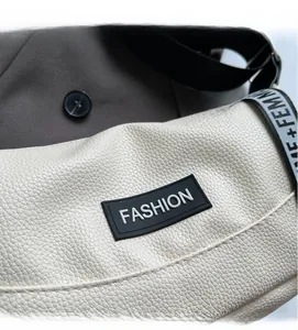 Close-up of white lychee leather texture and fashion rubber patch on the square bag