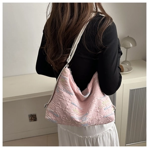 Sac fourre-tout rose à texture gaufrée et broderie sur l'épaule d'un mannequin