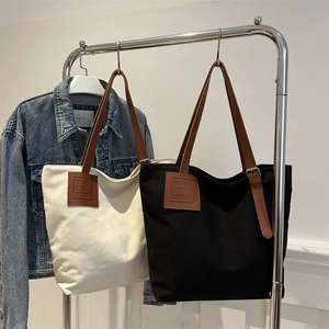 Large canvas tote bags in black and cream with adjustable brown leather handles