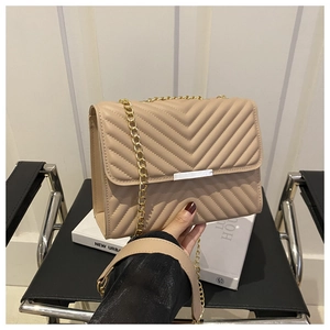 Dettaglio borsa trapuntata beige con catena dorata e tracolla in pelle morbida