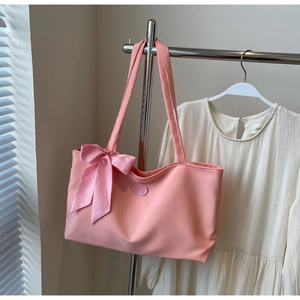 Detail of pink tote bag showing large capacity and decorative checkered bow accent