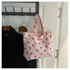 Close-up of pink corduroy tote bag featuring realistic red strawberry prints and texture