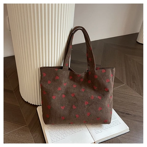 Détail du sac fourre-tout en velours côtelé marron café avec broderie de fraises et texture