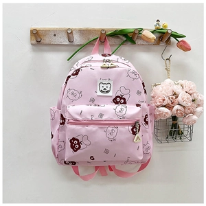 Detailansicht des rosa Schulrucksacks mit niedlichen Comic-Prints und Bären-Markenanhänger