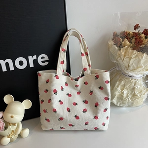Off-white corduroy tote bag with strawberry print and sturdy shoulder straps