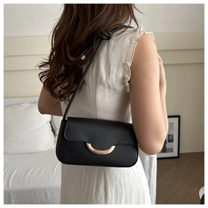 Vue arrière d'un mannequin portant un sac bandoulière noir avec boucle dorée en U