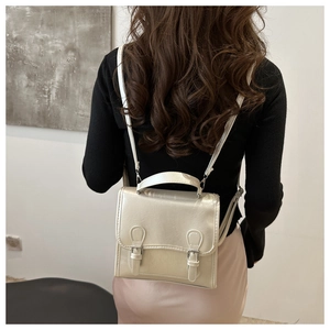 Detailansicht eines Mini-Rucksacks aus champagnerfarbenem Kunstleder mit Perleffekt
