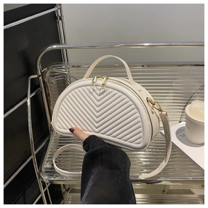 Detailansicht der weißen gesteppten Halbmond-Tasche mit V-Muster und goldenem Reißverschluss
