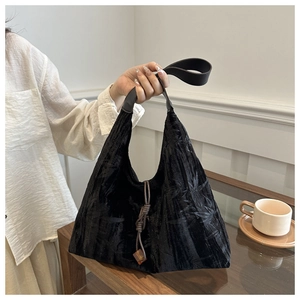 Détail du cabas noir avec texture de feuilles de bambou et pendentif tissé décoratif