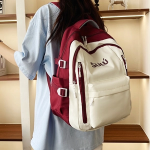 Detail of high-capacity vintage backpack showing red and white contrast and side buckles