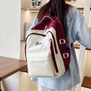 Detail view of red and white vintage colorblock backpack with Siii purple embroidery