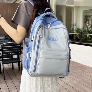 Detail of grey and blue contrast backpack featuring adjustable side buckles and water bottle pocket