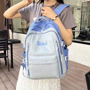 Detail view of large capacity blue and gray backpack with SÜLÜ logo on outdoor campus