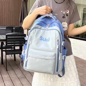 Detail of blue and grey color-blocked backpack with multiple compartments and side buckles