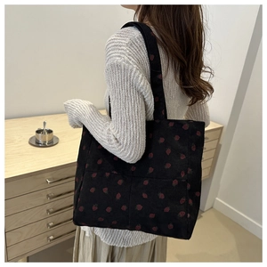 Detail of strawberry corduroy tote bag showing large capacity and soft texture
