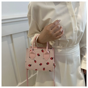 Detail of pink corduroy mini tote bag with strawberry print and leather handles