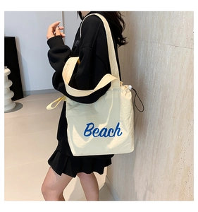 Detailansicht der cremefarbenen Tragetasche mit blauem Beach-Print und Kordelzug