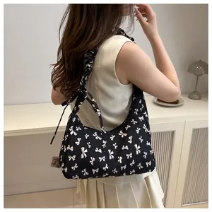 Detail of floral shoulder bag with scrunchie strap and ribbon bow tied on side
