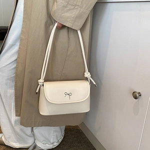 Chic cream-colored hobo bag with a silver bow accent and knotted shoulder strap