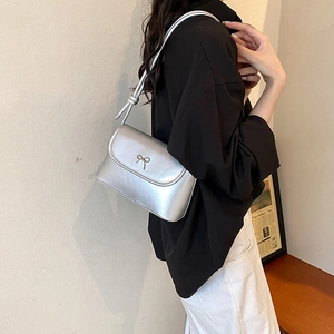 Chic silver metallic underarm bag for women with decorative bow and knotted strap detail