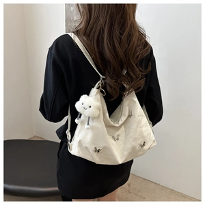 Detail of hobo bag featuring silver butterfly hardware and plush cloud charm