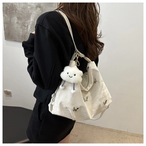 Detailed view of white high-capacity tote bag with butterfly accents and cloud charm