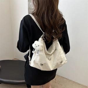 White pleated shoulder bag with silver butterfly charms and cloud plush toy accessory